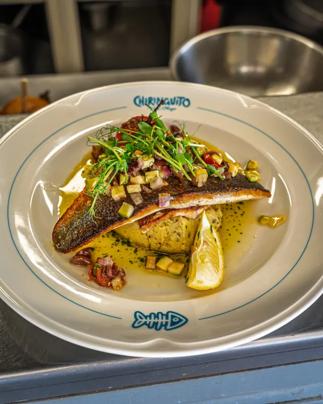 Filet de poisson du jour et ses légumes, servi dans l'assiette Chiringuito