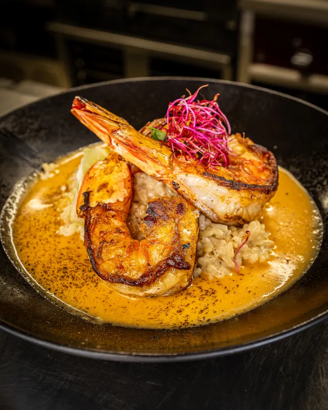 Gambas rôties, sauce curry et riz — plat signature du Chiringuito