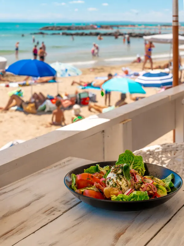 Salade fraîche servie face à la plage et aux baigneurs